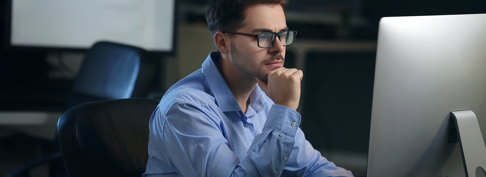 Keyvisual ZENNER AI: Mann sitzt an einem Schreibtisch vor einem Bildschirm