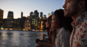 Personen vor einer städtischen Kulisse mit einem Fluss schauen in die Ferne
