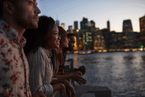 Personen schauen in die Ferne vor einer städtischen Kulisse